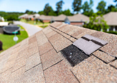 Missing shingles on roof due to storm damage.